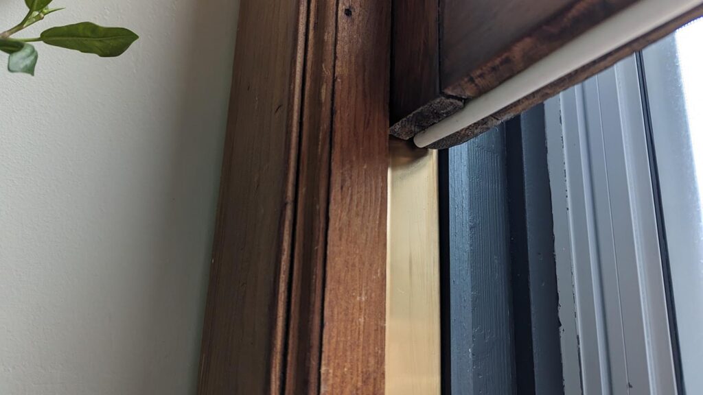 Old wooden window frame restoration with updated glazing and weatherproofing.