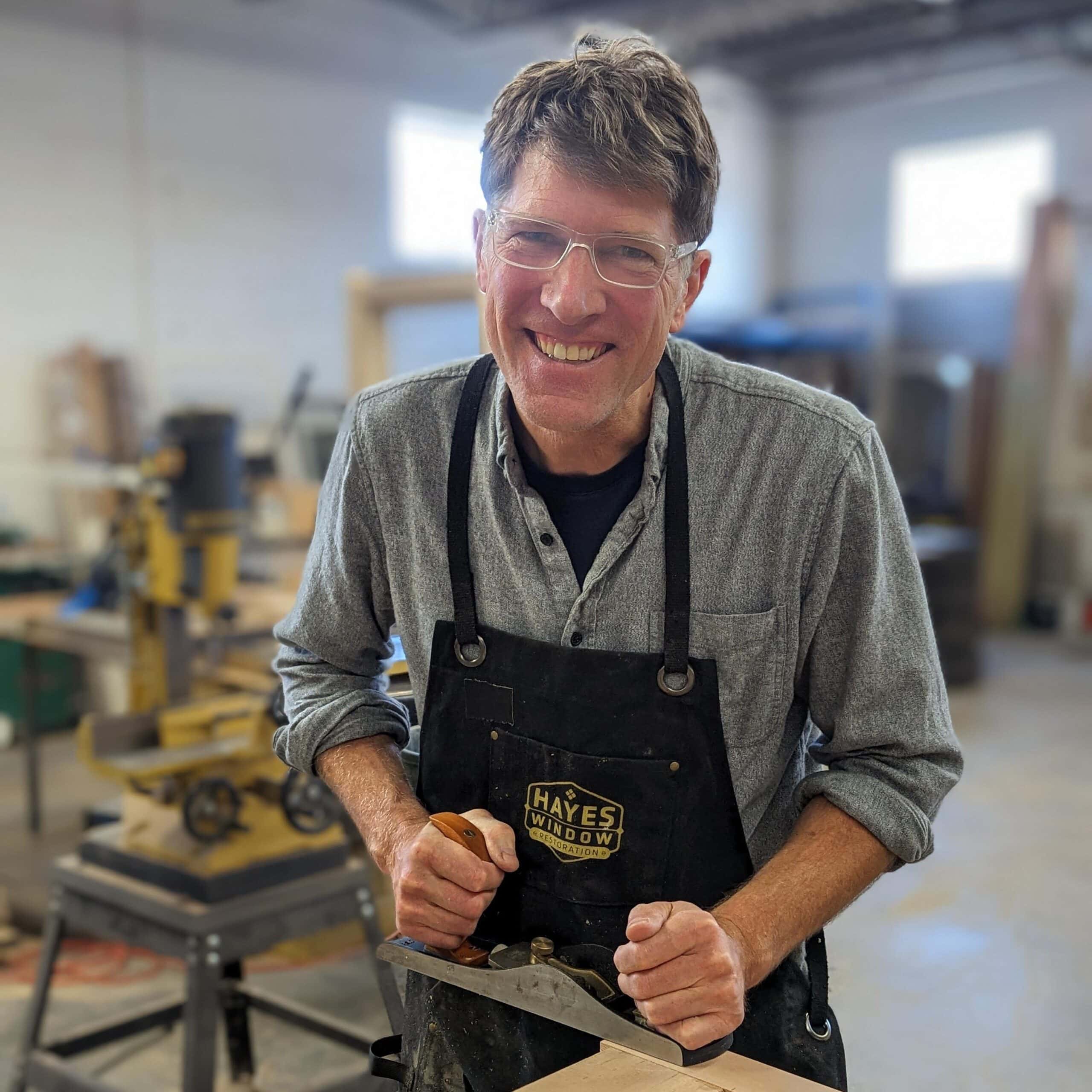 Restoration expert working on window frame at Hayes Window Restoration workshop.