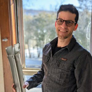 New Jersey window restoration expert holding window frame for repair or replacement.
