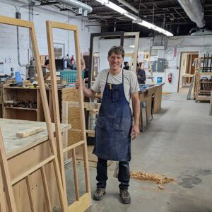 Refurbished wooden window frame in a woodworking shop, highlighting expert window restoration and craftsmanship skills.