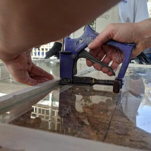 Precision window restoration with clamps securing glass in place.