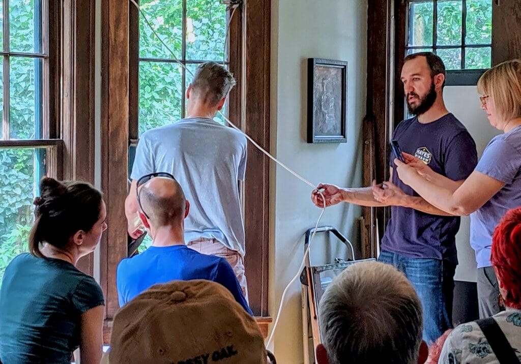 Old wooden window restoration demonstration with a team of professionals explaining techniques.