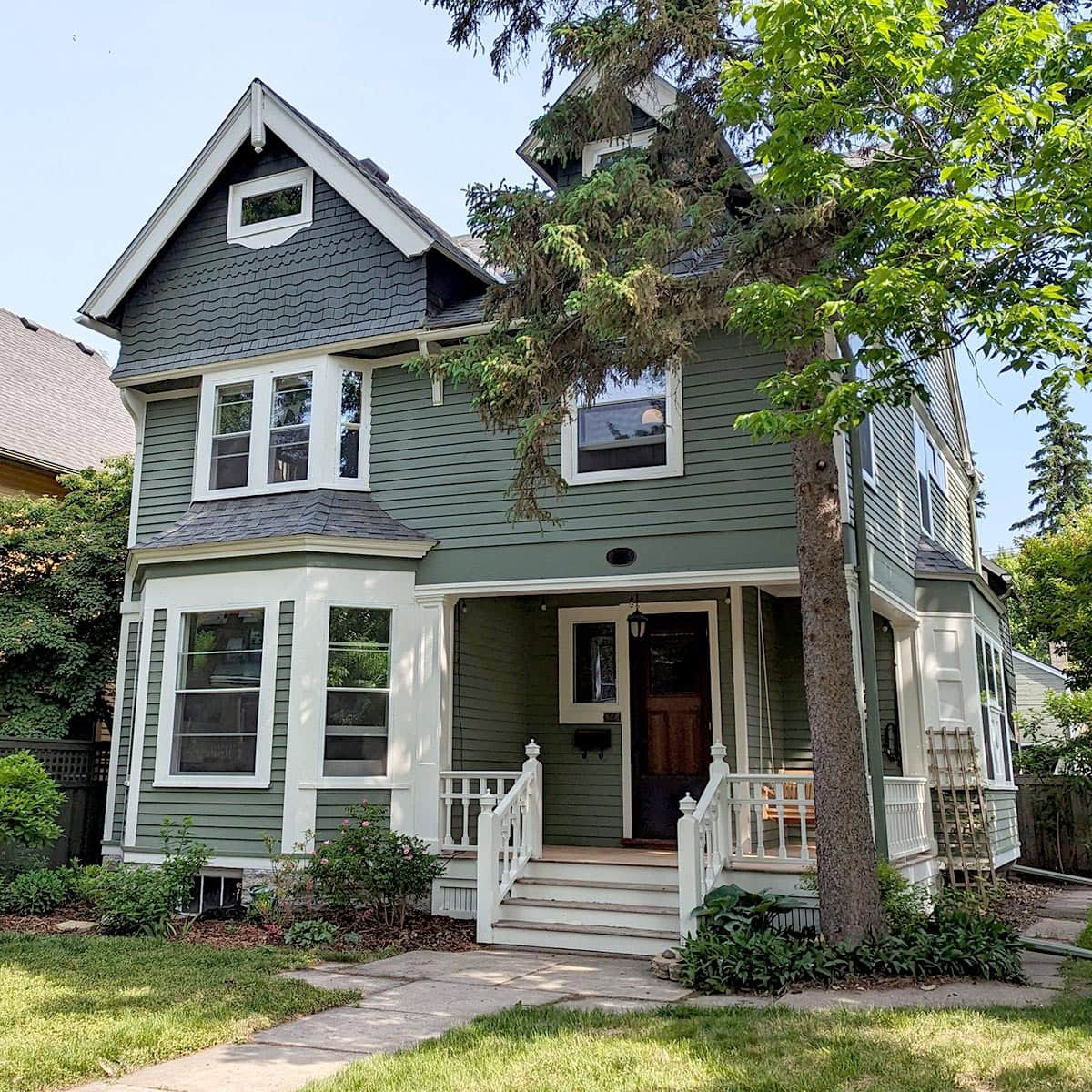 Old house window restoration with fresh paint and new sashes, enhancing curb appeal and energy efficiency.