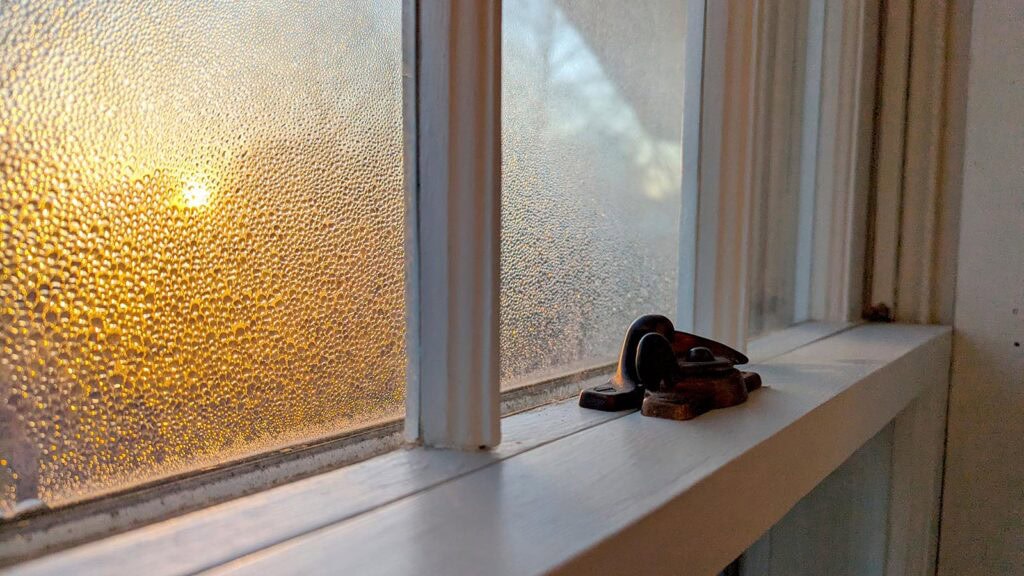 Frosted window with condensation, showing energy-efficient window restoration by Hayes Windows.
