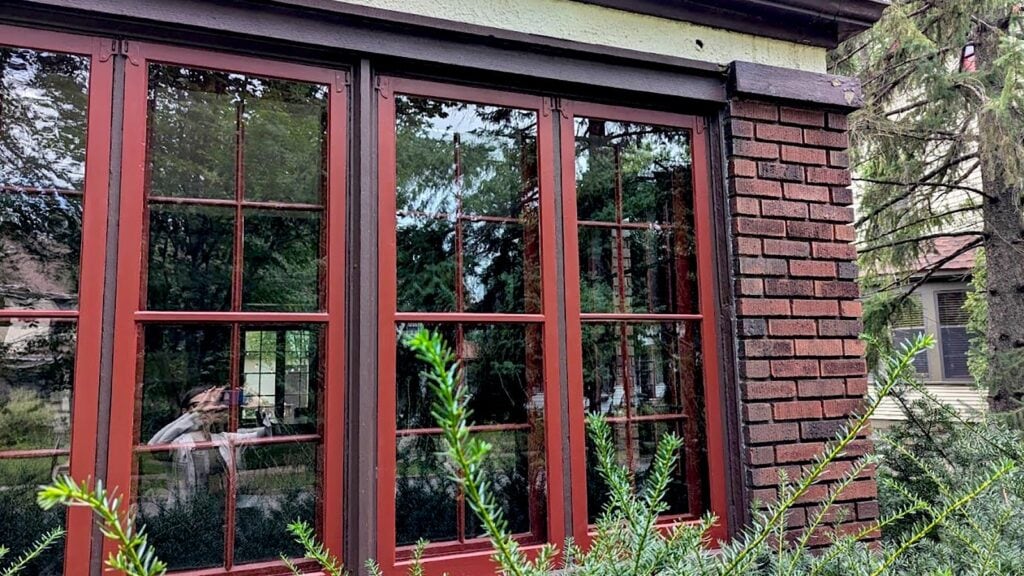 Refinished red brick window frames with restored wooden sash windows for enhanced historic home aesthetics.