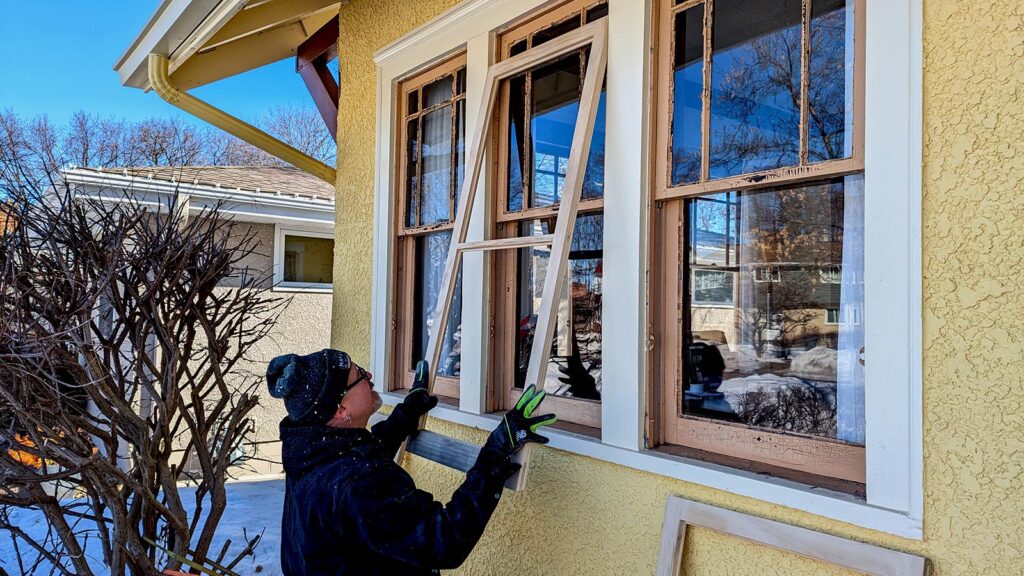 Refurbishing vintage wooden windows during house restoration project.