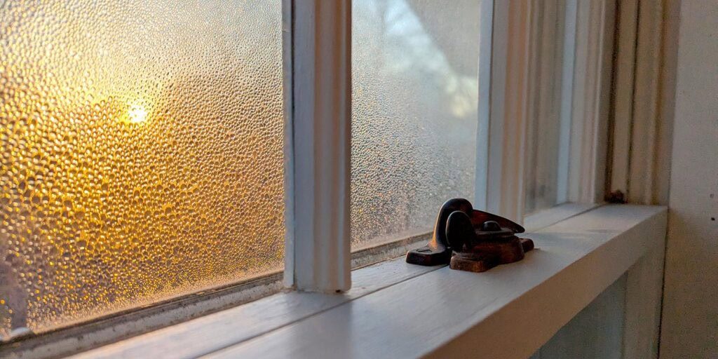 Frosted window with condensation, showing energy-efficient window restoration by Hayes Windows.
