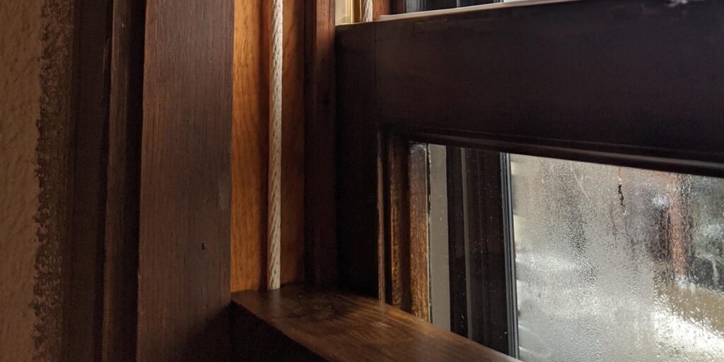 Weathered wooden window frame restoration by Hayes Window Restoration.