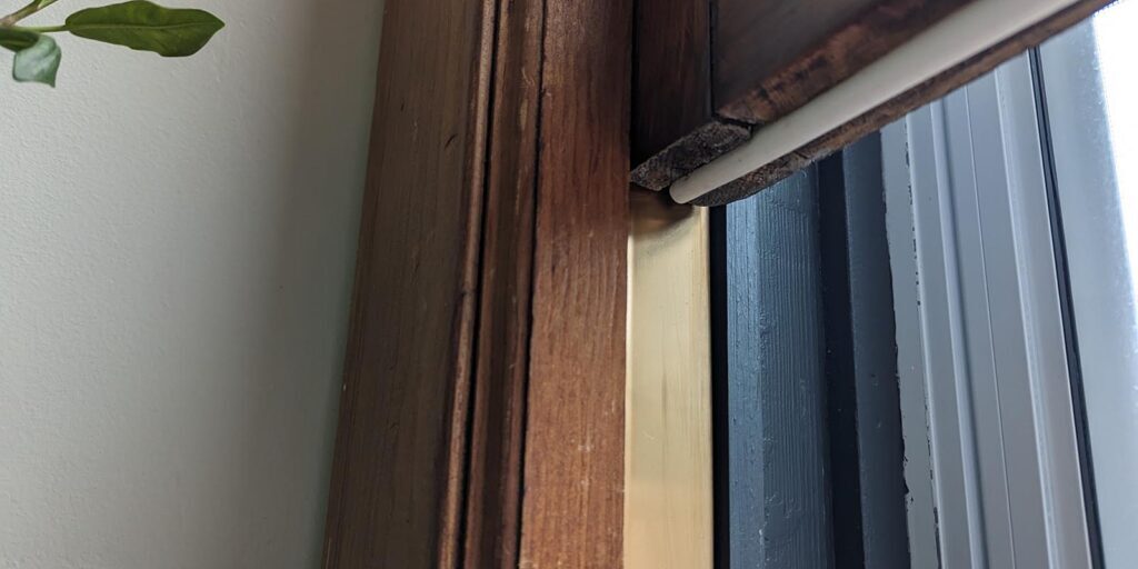 Old wooden window frame restoration with updated glazing and weatherproofing.