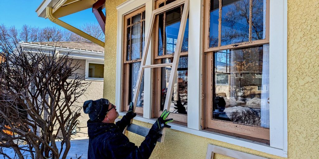Refurbishing vintage wooden windows during house restoration project.