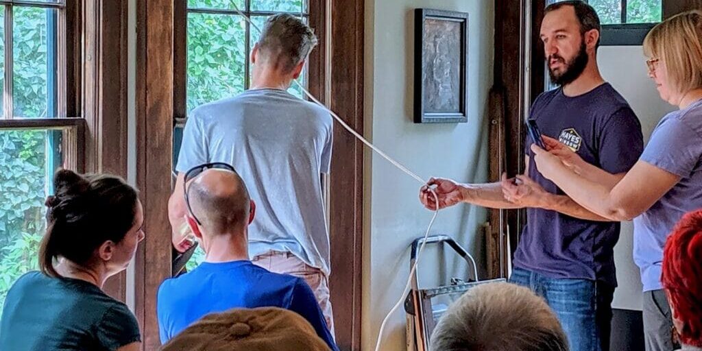 Old wooden window restoration demonstration with a team of professionals explaining techniques.